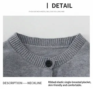 Détail du col rond côtelé et du bouton noir unique sur un cardigan en maille grise