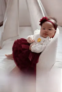 Detailed view of baby girls burgundy tutu set with lace collar top and floral headband