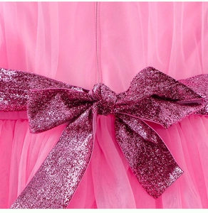 Macro detail of pink mesh tulle girl dress with a shimmering magenta glitter bow waistband