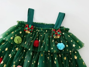 Detail of green Christmas tutu dress with gold stars, pom poms and bell bows