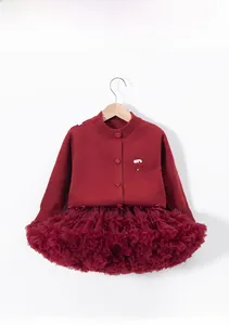 Détail du cardigan en maille bordeaux avec broderie nœud et jupe tutu à plusieurs couches