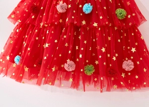 Detail of red tutu dress with gold stars and colorful plush pom-poms for toddler girls