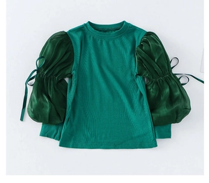 Detail of dark green ribbed knit bodice with organza puff sleeves and ribbon bows