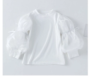 Detail of white rib-knit sweater featuring sheer organza puff sleeves and bow cuffs