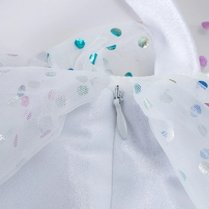 Détail de la fermeture éclair invisible sur robe blanche pour fille en tulle à pois