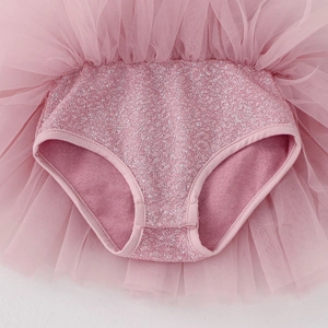 Close-up of pink girls' ballet tutu showing sequin bodice and snap buttons at the crotch