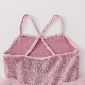 Detail of pink leotard showing sparkling glitter fabric and crisscross back straps