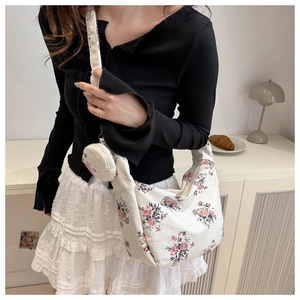 Floral corduroy crossbody bag set with small round coin purse worn by a model