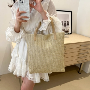 Large woven straw tote bag with brown leather handles for summer vacation style