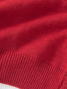 Gros plan sur un tricot rouge avec texture dense et ourlet côtelé pour vêtements fille