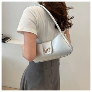 Sac à bandoulière demi-lune en similicuir argenté avec nœud doré porté par un mannequin