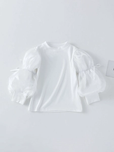 Girls white ribbed knit top with sheer puff sleeves and elegant bow tie details