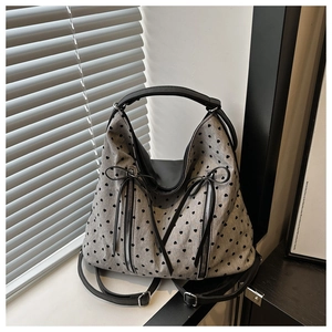 Detail showing grey canvas tote bag with heart patterns and black ribbon bow decorations
