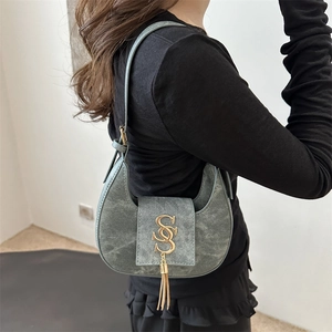 Sac croissant vert foncé minimaliste avec logo S doré et gland métallique élégant