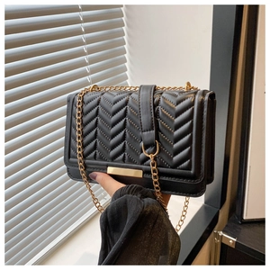 Detailed view of black PU leather bag with V-shaped quilting and golden chain strap