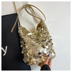 Dettaglio ravvicinato di una borsa a secchiello con paillettes dorate e trama metallica