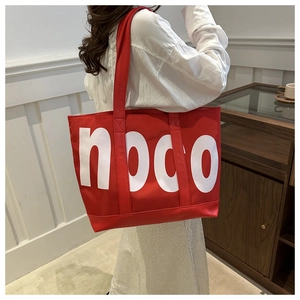 Vista lifestyle di una grande borsa tote hodo rossa in nylon indossata da una modella
