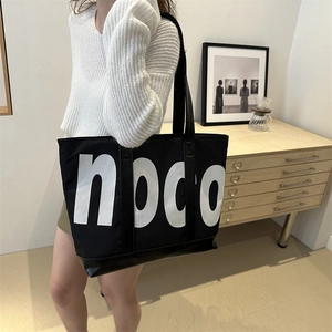 Grande borsa tote nera minimalista con stampa di lettere noco bianca per il pendolarismo