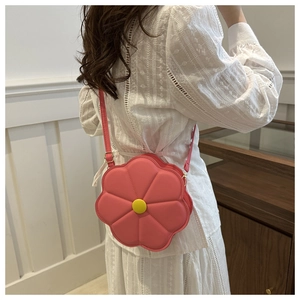 Dettaglio della borsa a tracolla rosa a forma di fiore con centro giallo e tracolla in PU