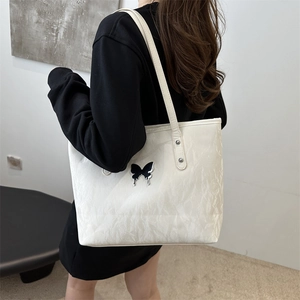 White marble texture tote bag with butterfly detail shown on a model's shoulder
