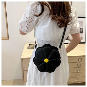 Dettaglio di una borsa a tracolla floreale nera e gialla indossata da una modella