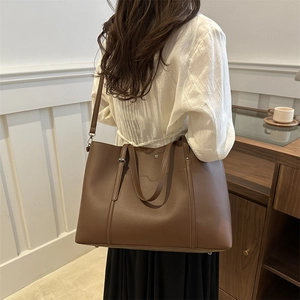 Large dark brown leather tote bag with dual handles and adjustable strap for women
