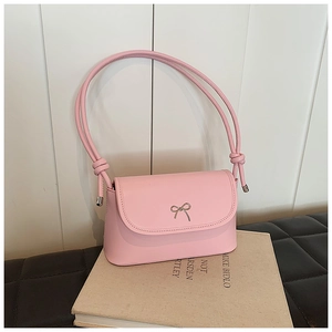 Detail of pink shoulder bag featuring silver bow metal buckle and knotted strap