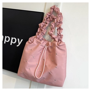 Close-up of pink tote bag featuring pleated handles and sparkling rhinestone details