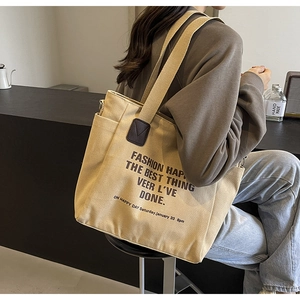 Détail de la poche latérale du sac en toile et de la bandoulière avec décor en cuir