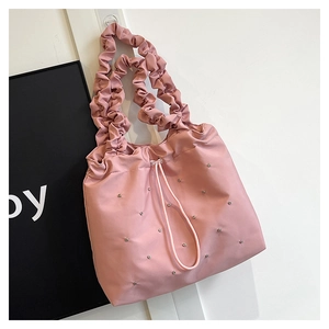 Detail of pink tote bag showing ruched cloud strap and sparkling rhinestone accents