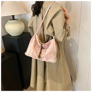 Detail of light pink pleated tote bag with bamboo texture and brown tassel knot