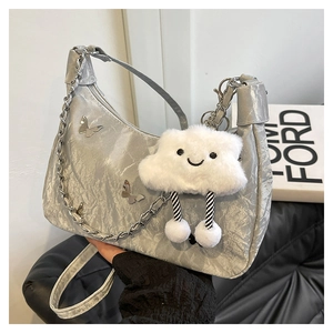 Detail of silver pleated shoulder bag with butterfly accents and plush cloud charm