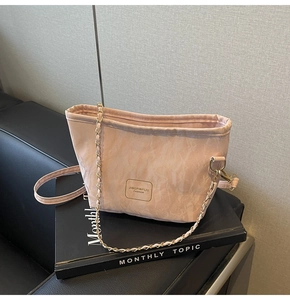 Vue détaillée du sac seau rose avec bandoulière en chaîne métallique et logo de la marque