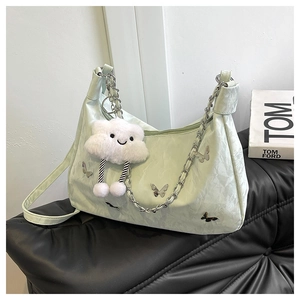 Détail du sac hobo vert menthe avec papillon, chaîne et charme nuage blanc