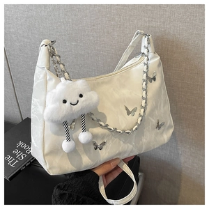 Détail d'un sac hobo plissé blanc avec patch papillon et breloque nuage doux