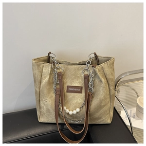 Detail of khaki vintage canvas tote with leather handles and decorative pearl chain