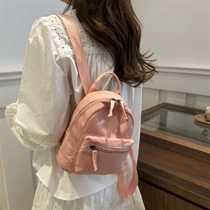 Mini sac à dos rose en nylon pour femme avec bretelles porté par un mannequin