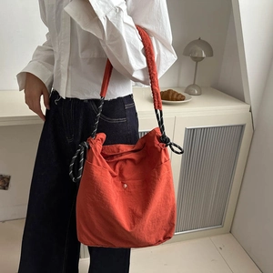 Large orange canvas bucket bag with woven drawstring rope strap for daily commuting