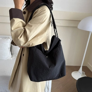 Minimalist black nylon shoulder tote bag with contrasting stitching for casual daily use