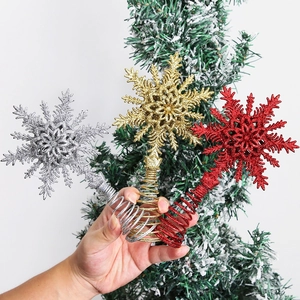 Close-up of sparkling gold silver and red snowflake tree toppers with spiral spring base