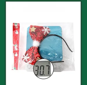Detailed view of red sequin Christmas bow headband weighing 30.7g on a scale