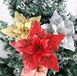 Close-up of glittery red, gold, and silver artificial poinsettia flowers for Christmas trees