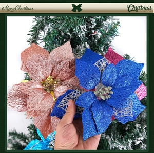 Close-up of sparkling blue fabric poinsettia with glitter mesh petals for Christmas tree deco