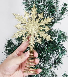 Detail of a sparkling gold glitter snowflake topper for a Christmas tree decoration