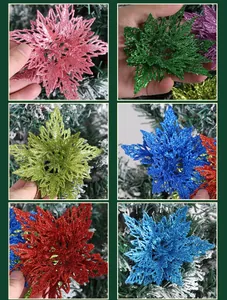 Detail of multi-color double-layer glitter Christmas flowers on a snowy pine tree