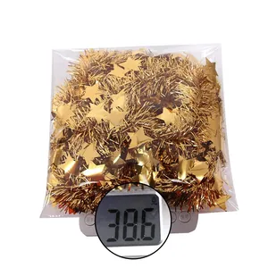 Weight measurement of 2m gold star tinsel garland showing 38.6g on a digital scale