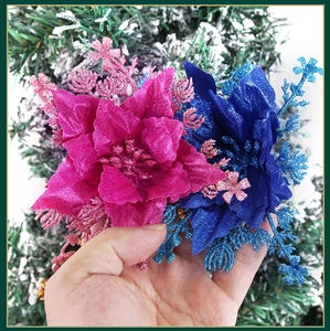 Detail of sequined artificial poinsettia flowers in pink and blue for Christmas trees