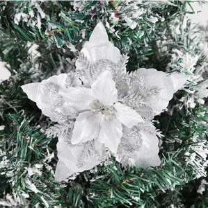 Close-up of 16cm silver glitter poinsettia flower on snowy pine branch background