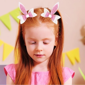 Pink and white glitter bunny ear hair clips with fuzzy pom-pom detail for girls