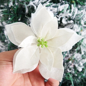 Macro shot of 12cm white velvet artificial poinsettia with green stamen detail